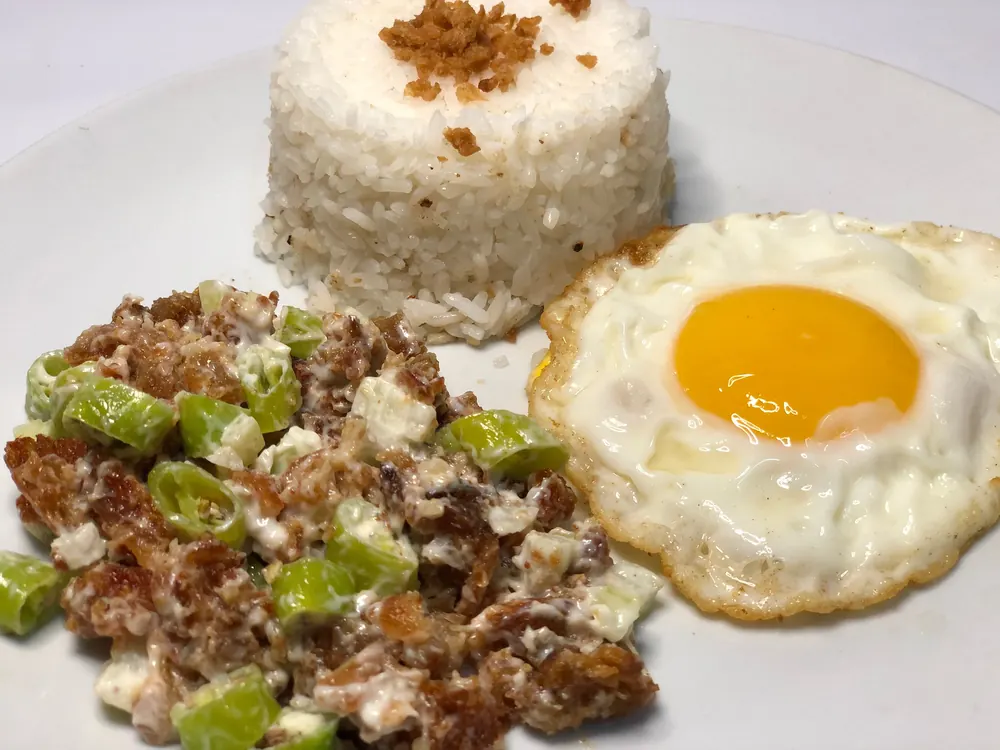 Sisig with garlic rice and a sunny-side-up egg